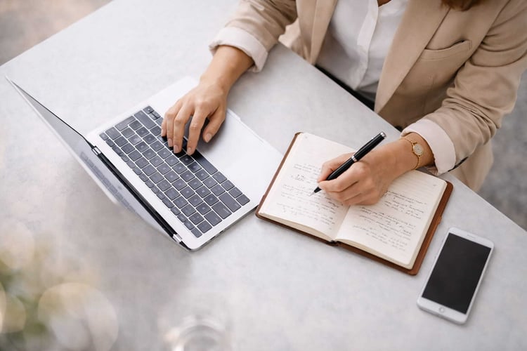 Person schreibt Notizen am Arbeitsplatz